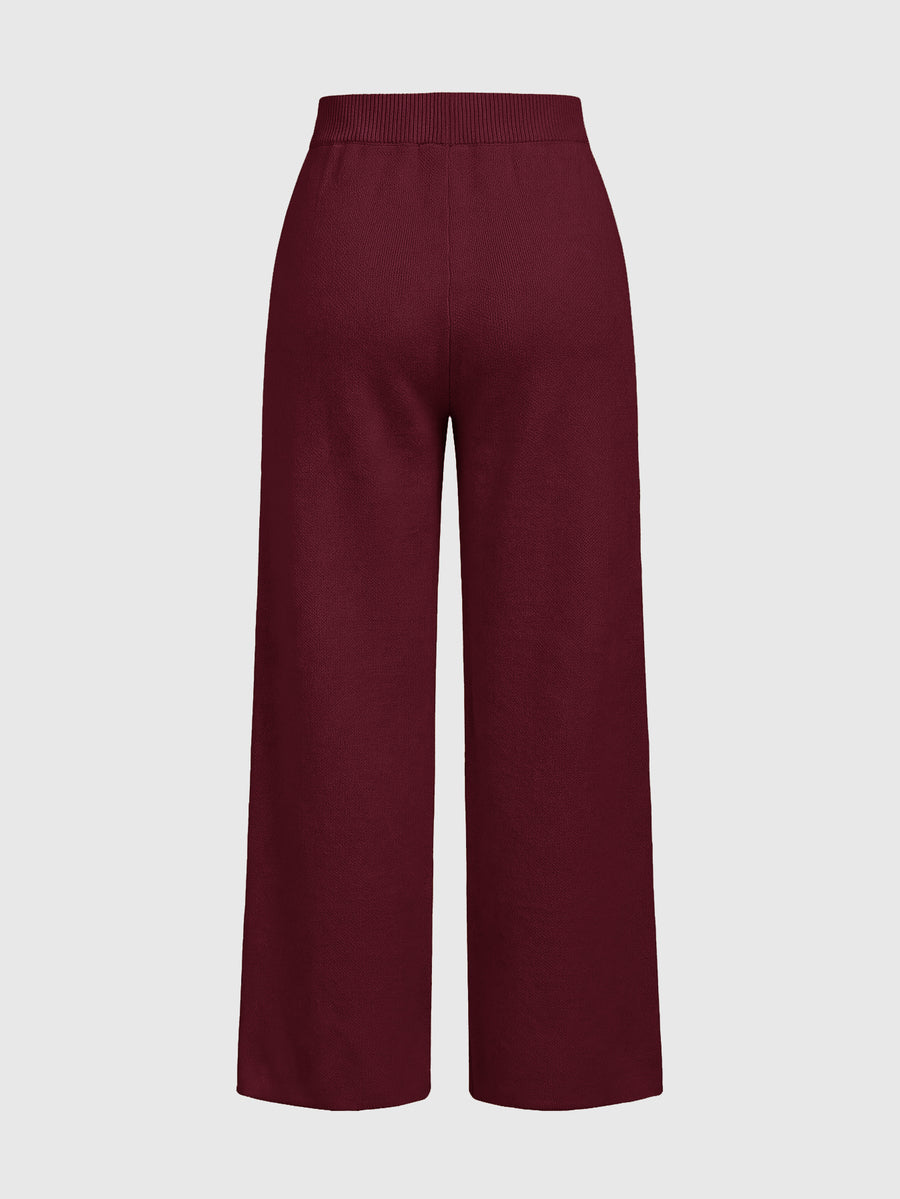 Women's two-piece rib-knit sweater set featuring a long-sleeve cold-shoulder crop top with strap details and matching wide-leg pants.