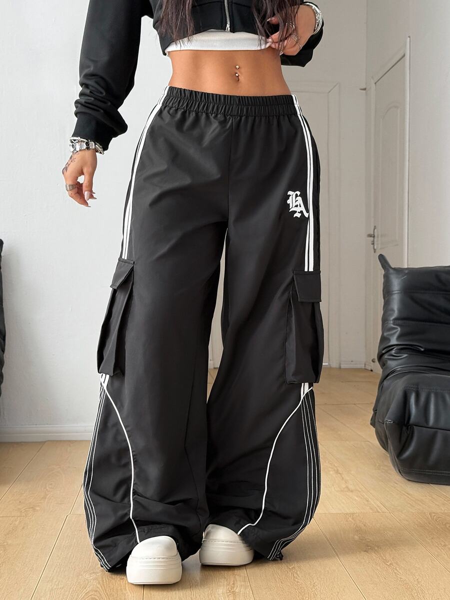Women's plus size loose straight leg pants featuring a black and white color block design with side stripes and an elastic drawstring waist.