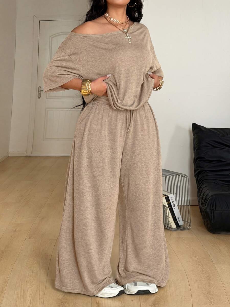 Women's casual two-piece outfit featuring a loose short-sleeve asymmetrical neck t-shirt and matching long wide leg pants with pockets.