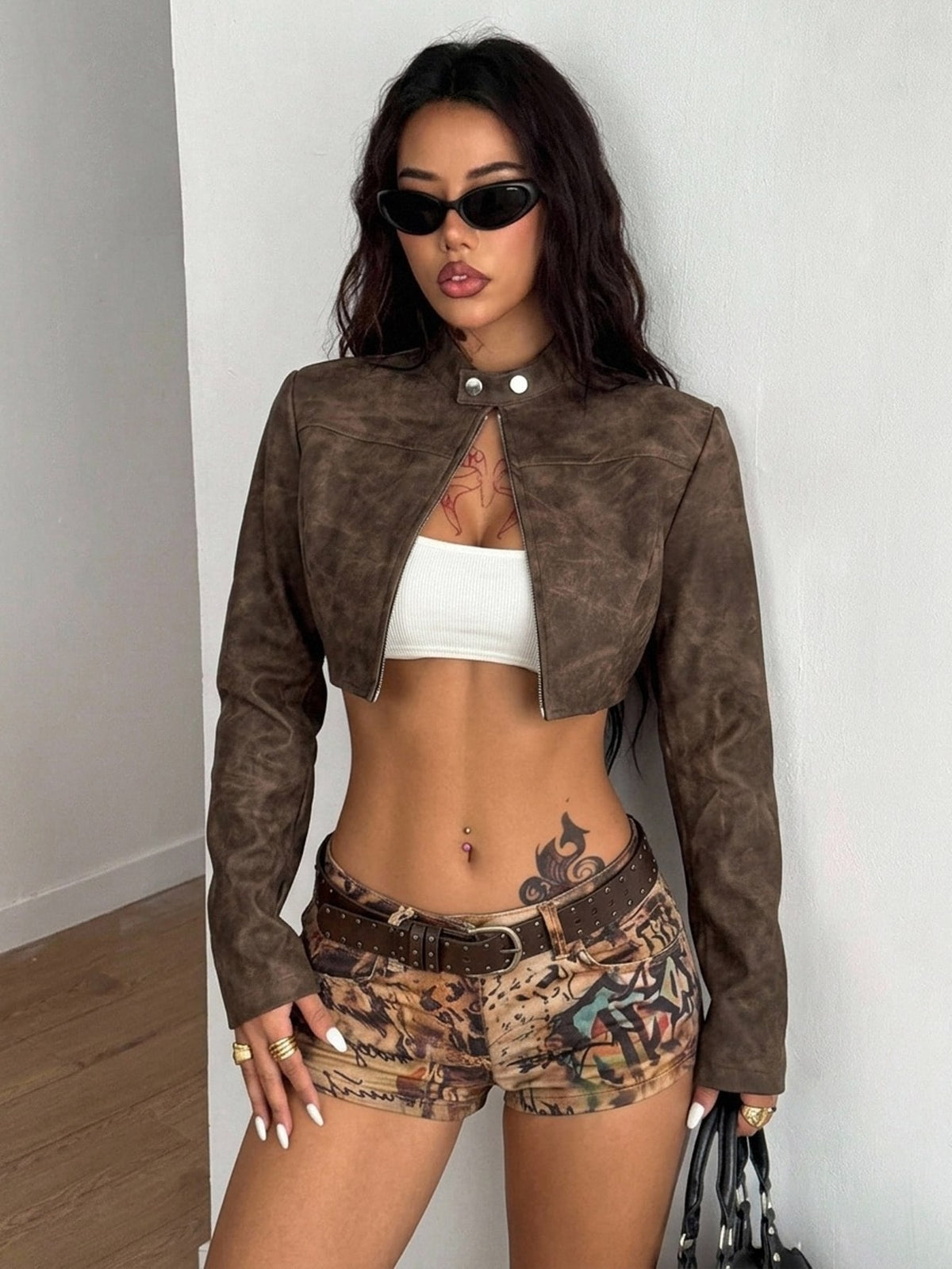 Front view of a women's black cropped PU leather jacket featuring a stand collar, long sleeves, and front zipper closure.