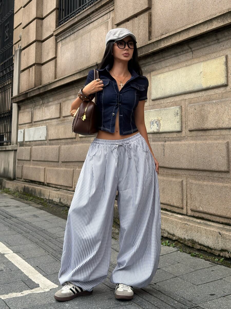 Women's loose-fit black bloomer pants made of 100% cotton featuring an elastic waistband and side pockets.