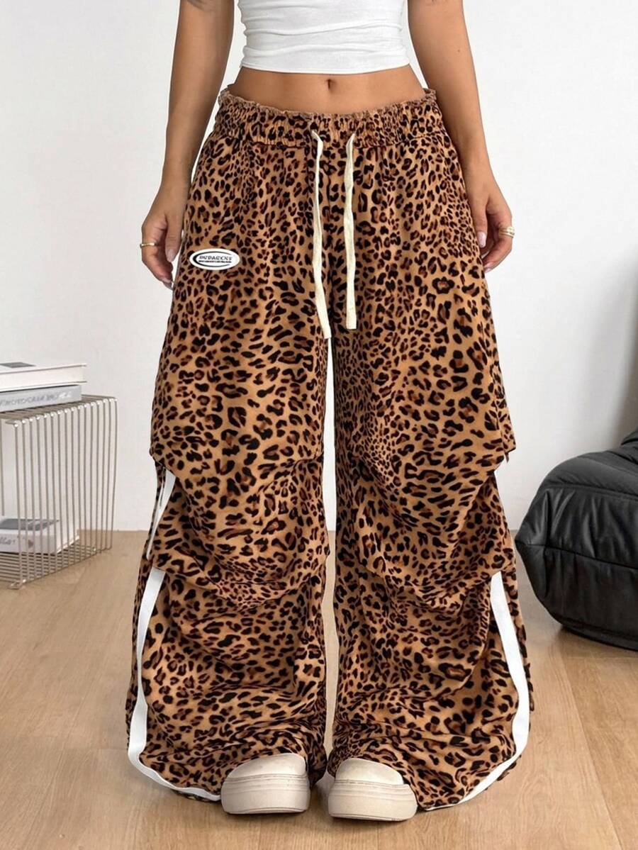 Women's black and white striped wide leg pants featuring an elastic drawstring waistband, side pockets, and a loose straight leg fit.