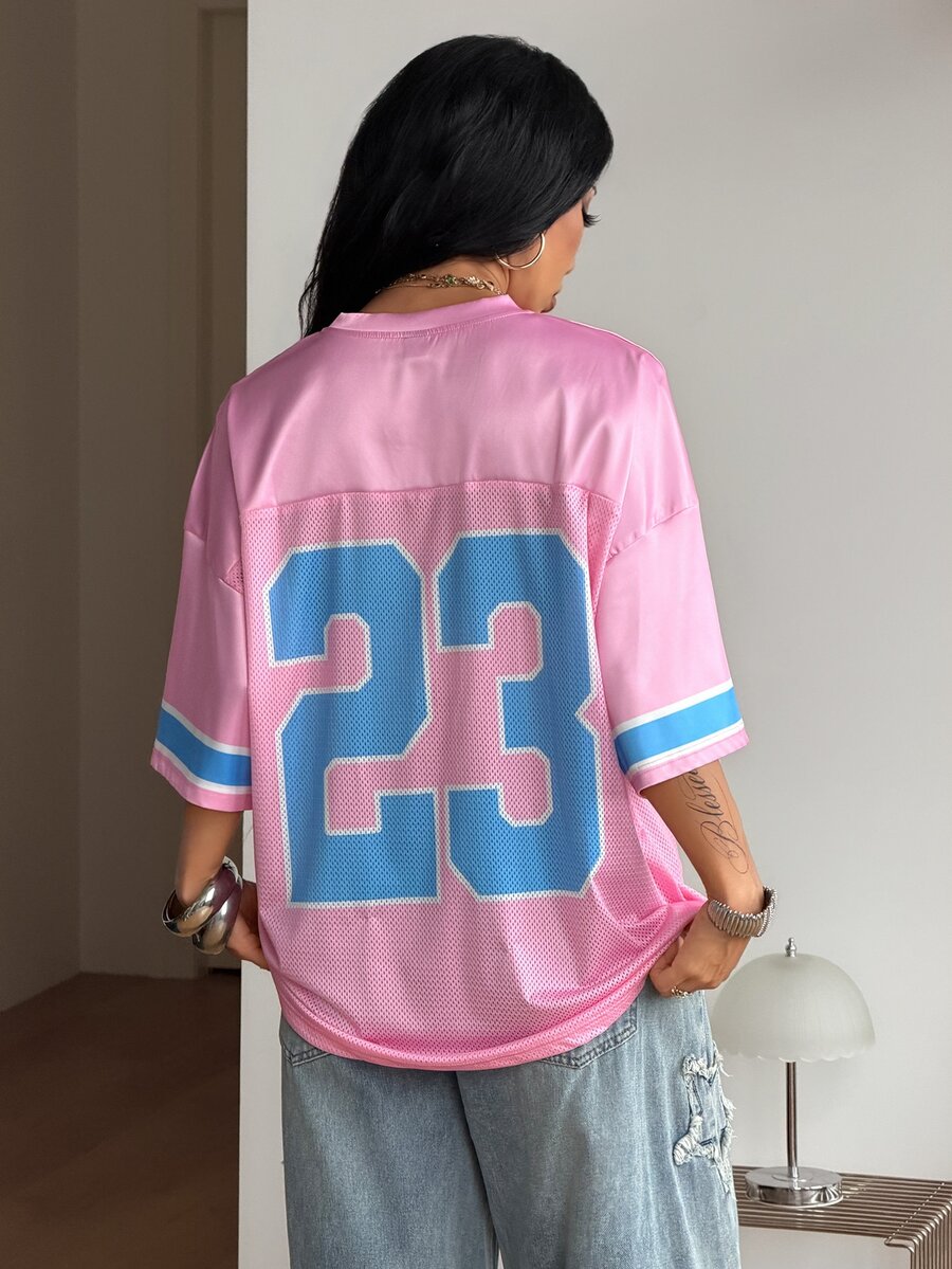 Oversized short-sleeve football jersey top featuring a V-neckline, contrast binding, and graphic number print.