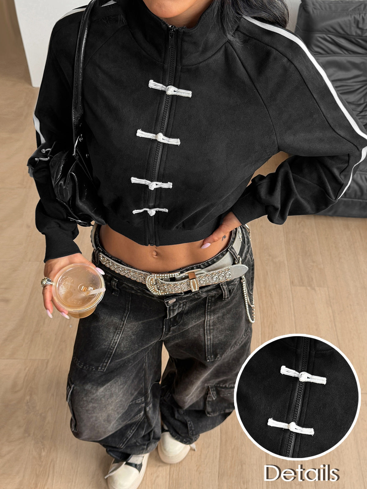 Women's black cropped track jacket with white colorblock tape details, stand collar, and front zip closure.
