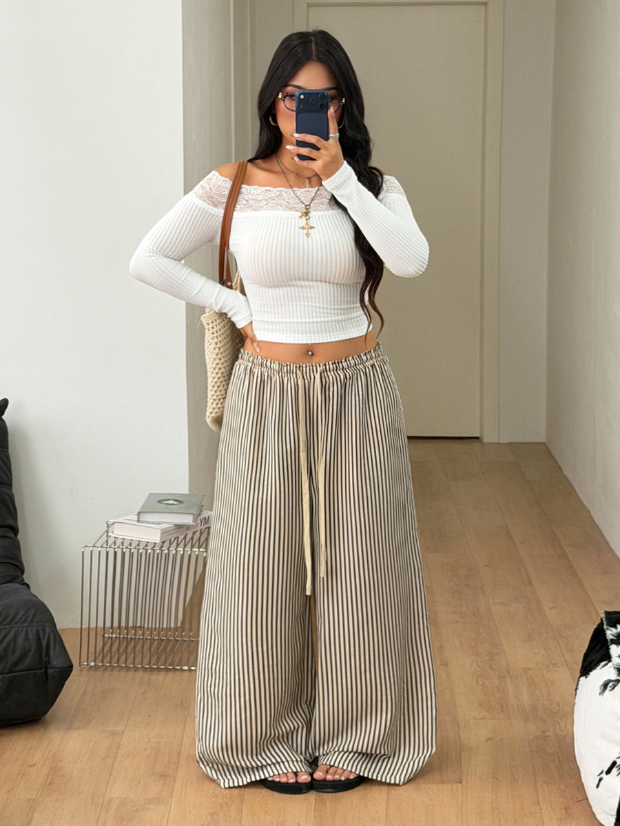 Women's loose straight leg cotton pants featuring a high waist with an adjustable drawstring knot and functional side pockets.