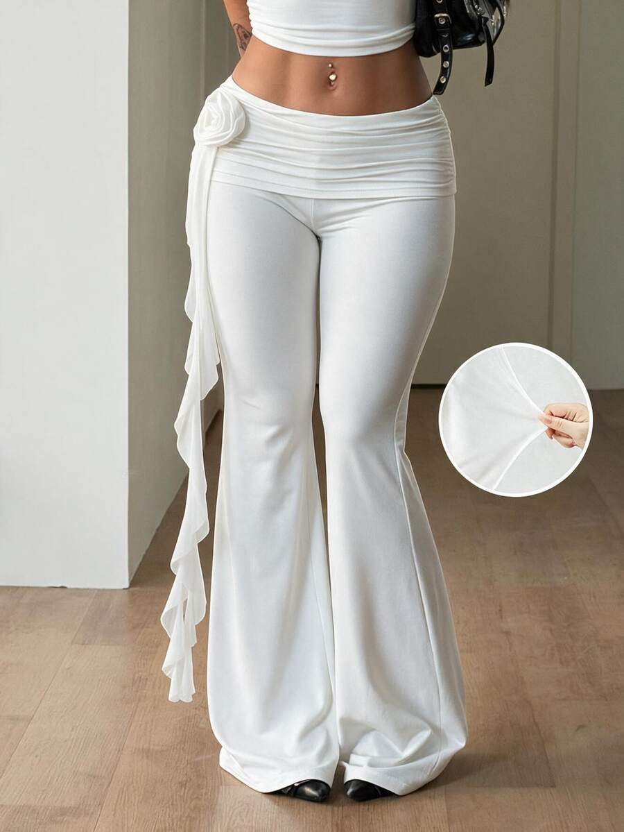 Black low waist flare pants featuring 3D rose and side stripe detailing in stretchy mesh fabric.