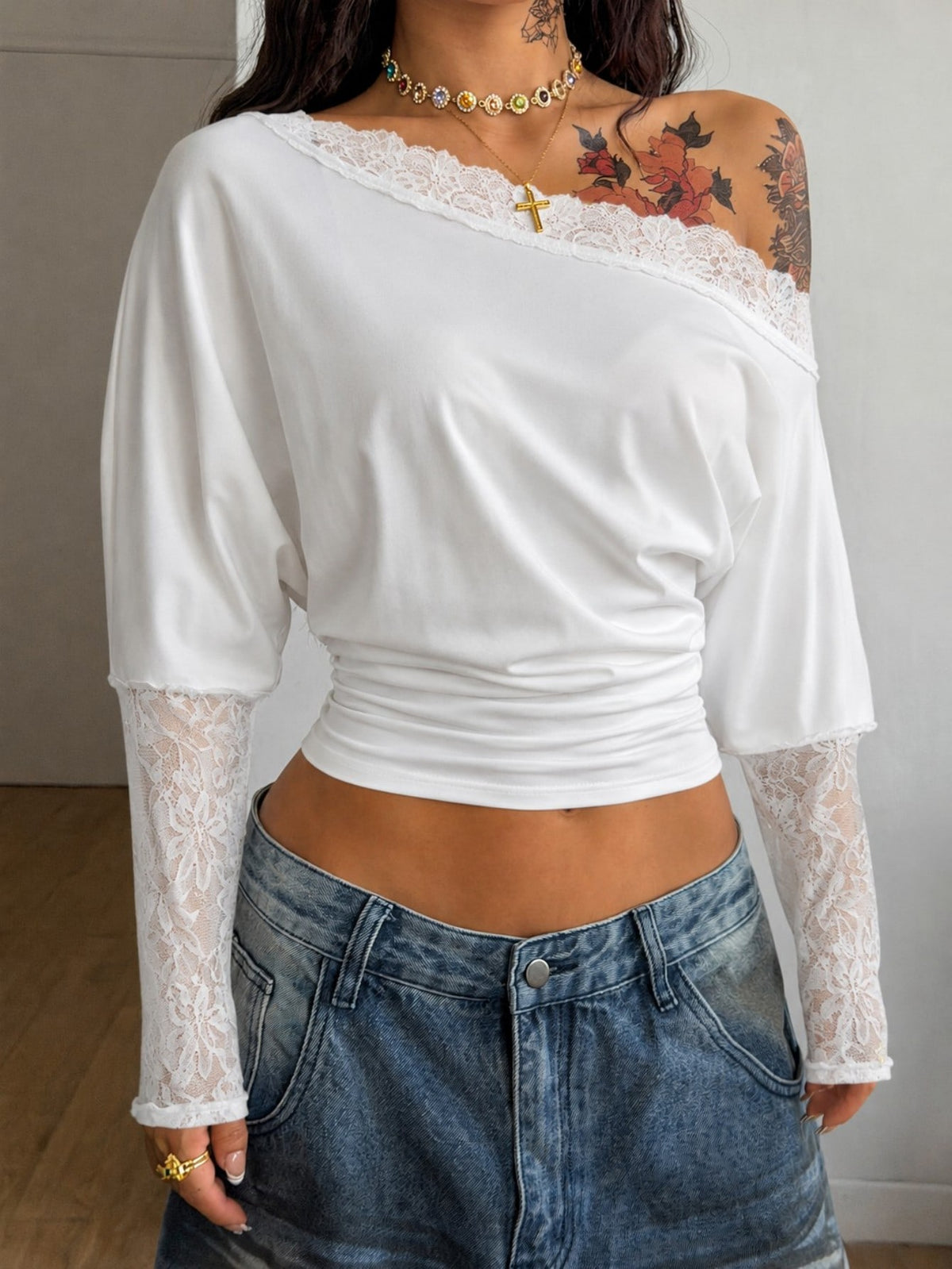 Women's black long sleeve t-shirt featuring delicate contrast lace details and a boat neckline in a knitted stretch fabric.
