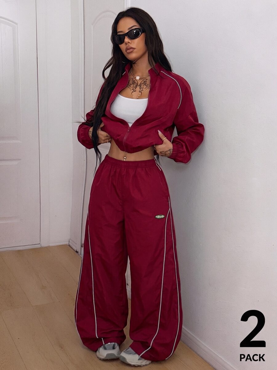 Women's two-piece sporty casual tracksuit set featuring a stand collar zip-up jacket with contrast binding and matching loose parachute pants.
