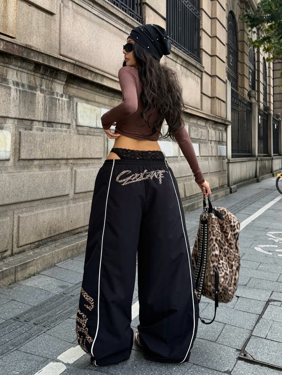 Women's black loose fit wide leg pants featuring an elastic waistband and side pockets with contrast binding.