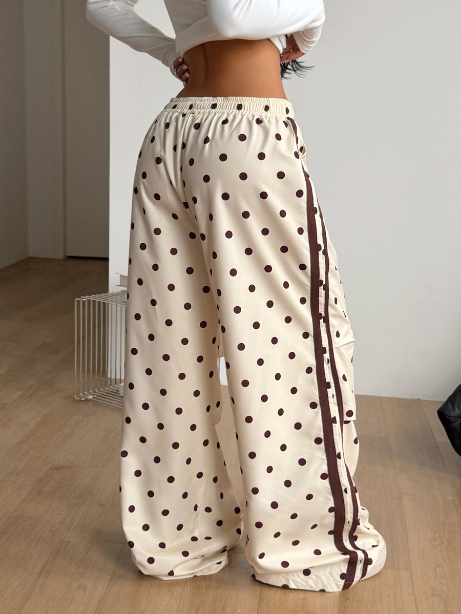 Women's black and white striped wide leg pants featuring an elastic drawstring waistband, side pockets, and a loose straight leg fit.