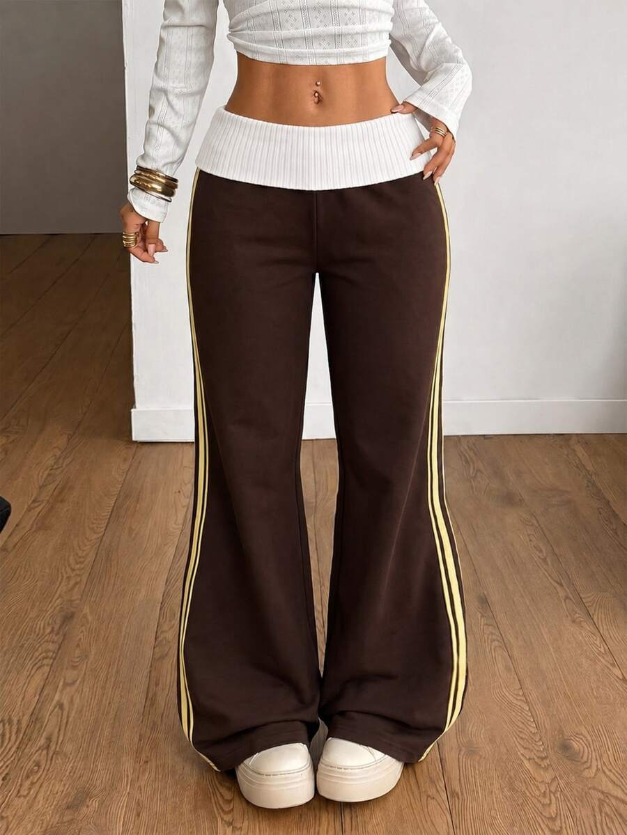 Women's wide leg flare sweatpants featuring a black and white colorblock contrast fold waistband and side stripe details.