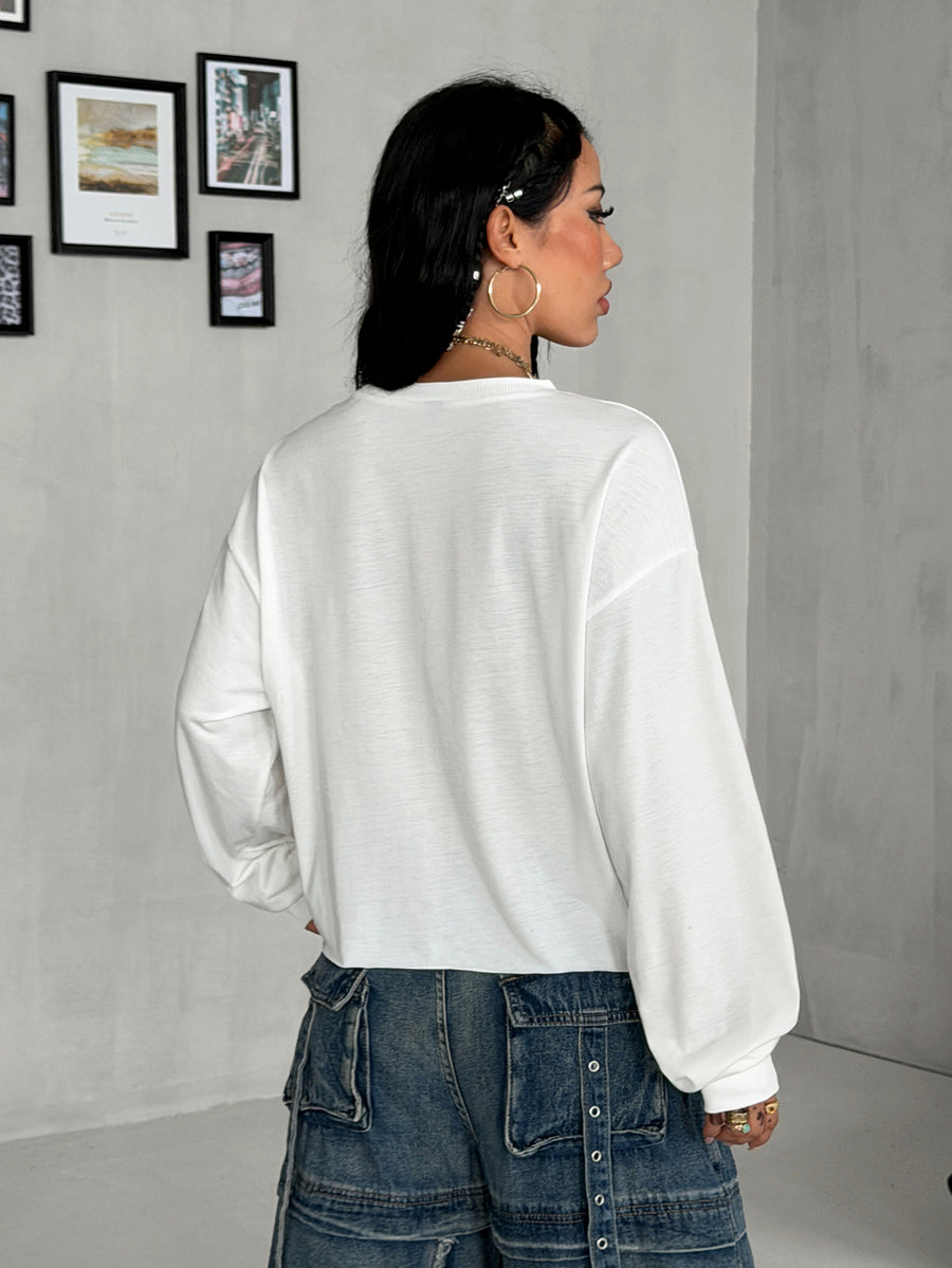Women's white oversized long sleeve graphic T-shirt with drop shoulders and a round neckline.