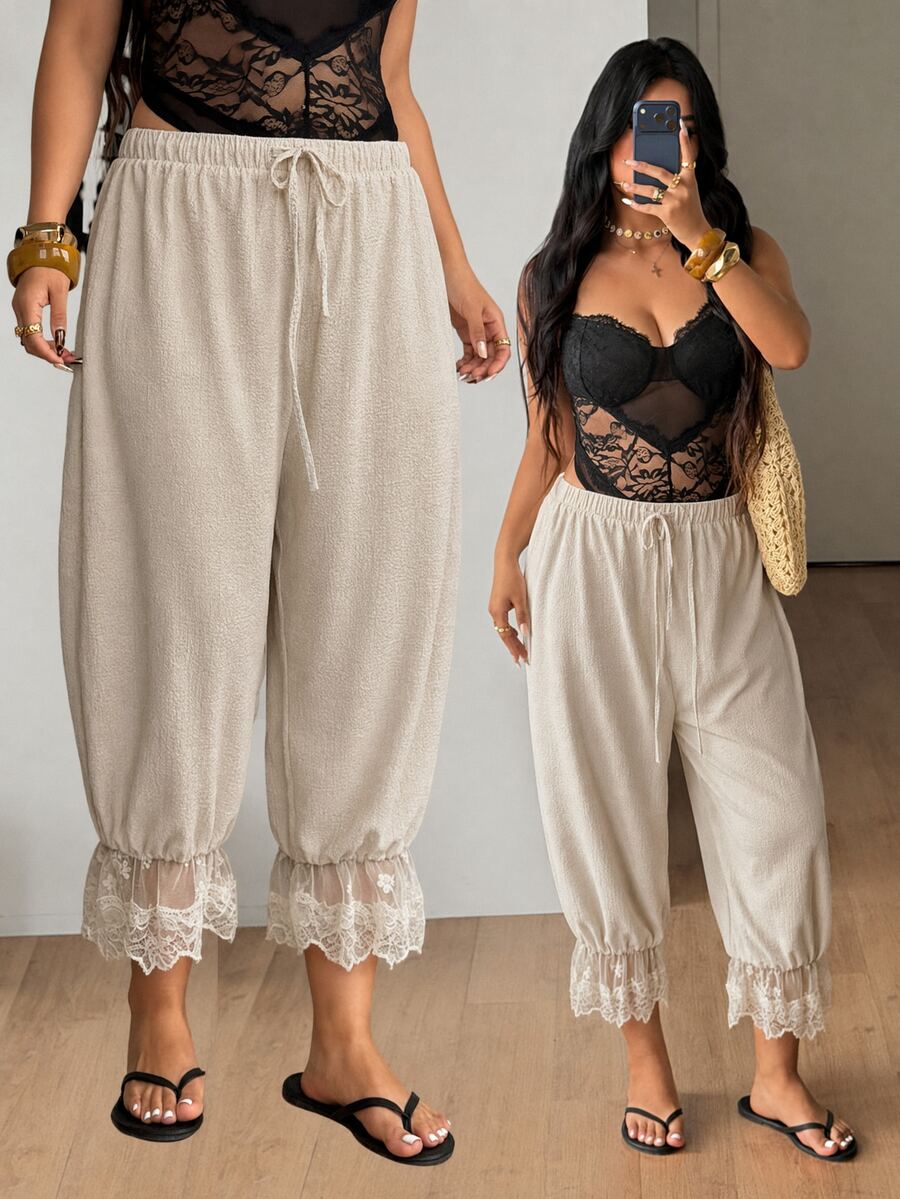Women's loose-fitting lantern bloomer pants in capri length featuring delicate contrast lace trim and a drawstring waist.