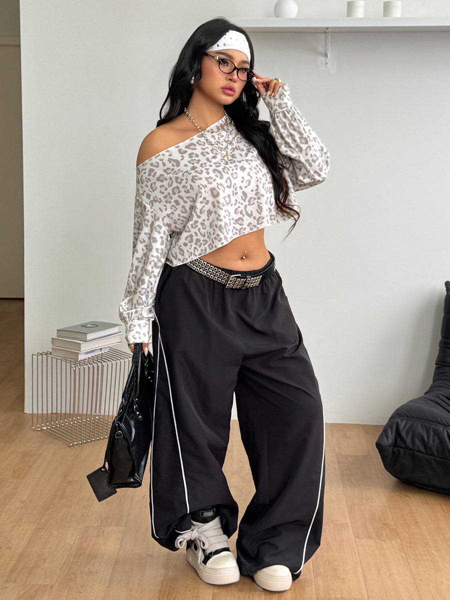 Plus size women's cropped leopard print sweatshirt featuring an asymmetrical neckline and long drop-shoulder sleeves.