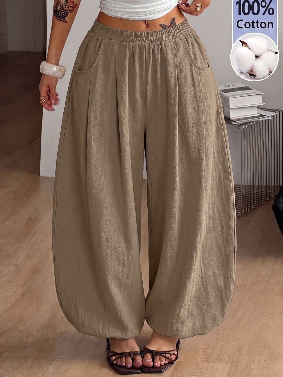 Women's loose-fit black bloomer pants made of 100% cotton featuring an elastic waistband and side pockets.