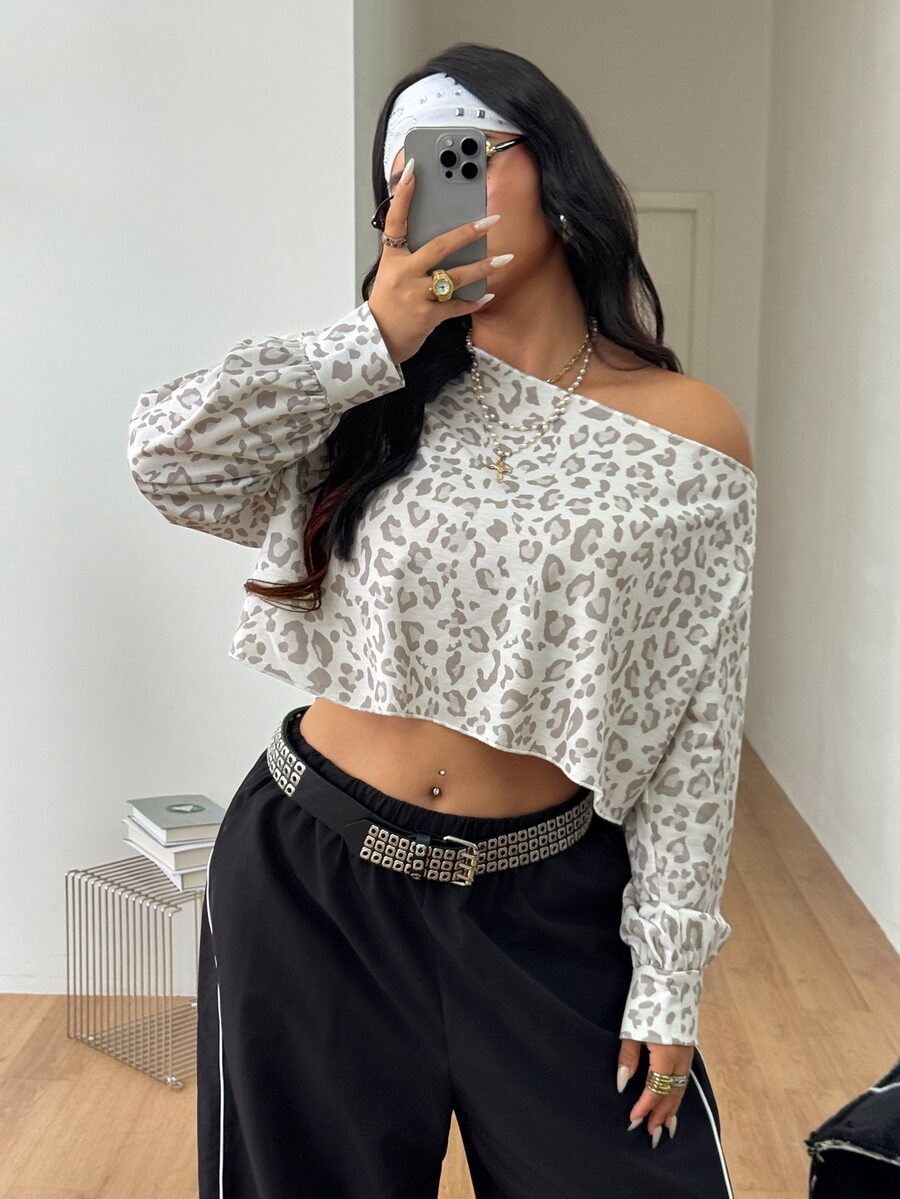 Plus size women's cropped leopard print sweatshirt featuring an asymmetrical neckline and long drop-shoulder sleeves.
