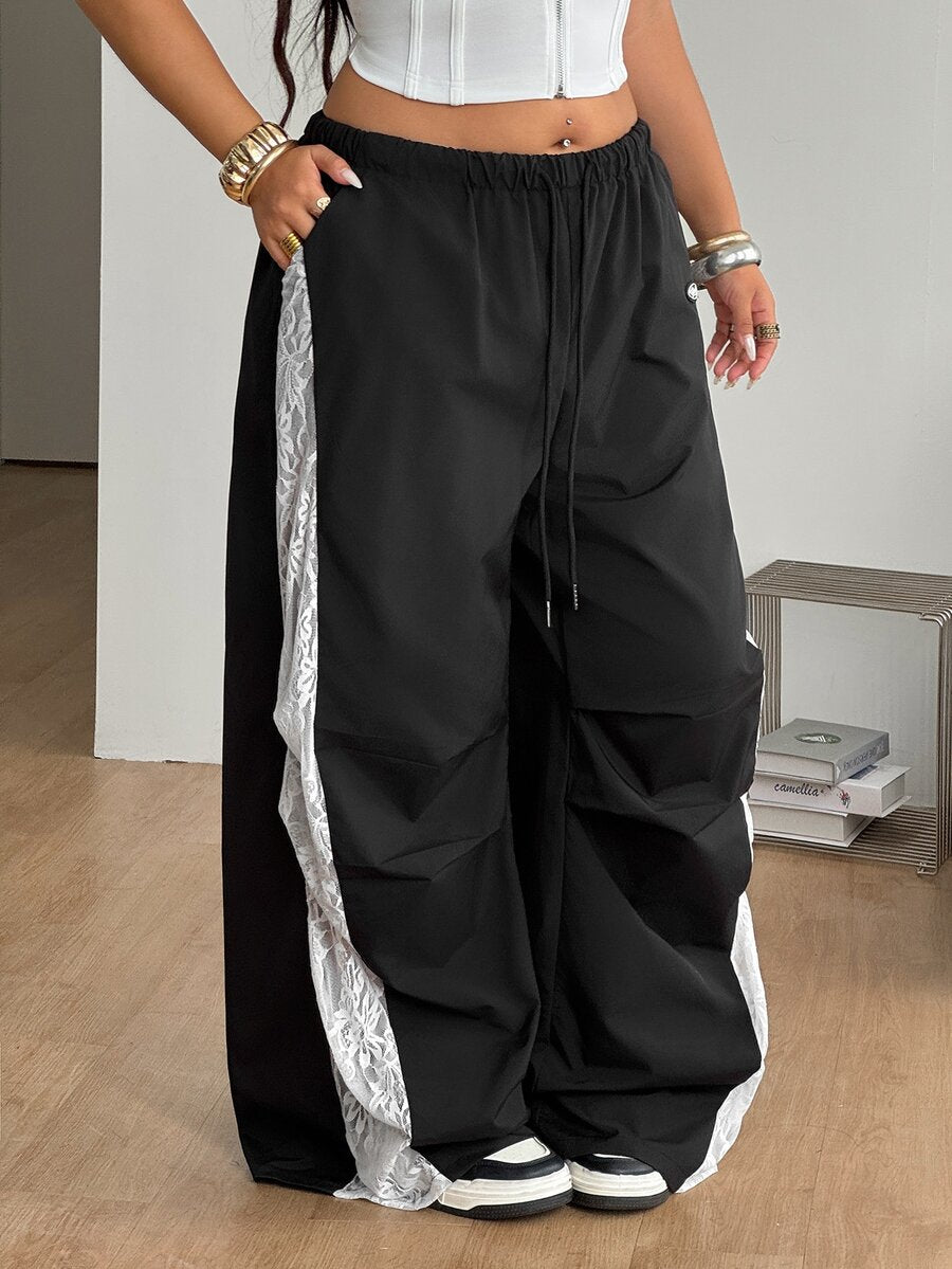 Women's high waist wide leg pants in black featuring leopard print patchwork details and an elastic drawstring waistband.