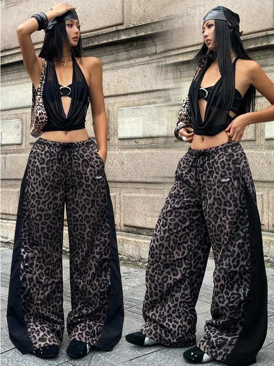 Women's black baggy jogger pants with an adjustable drawstring waist and colorblock polka dot geometric pattern.