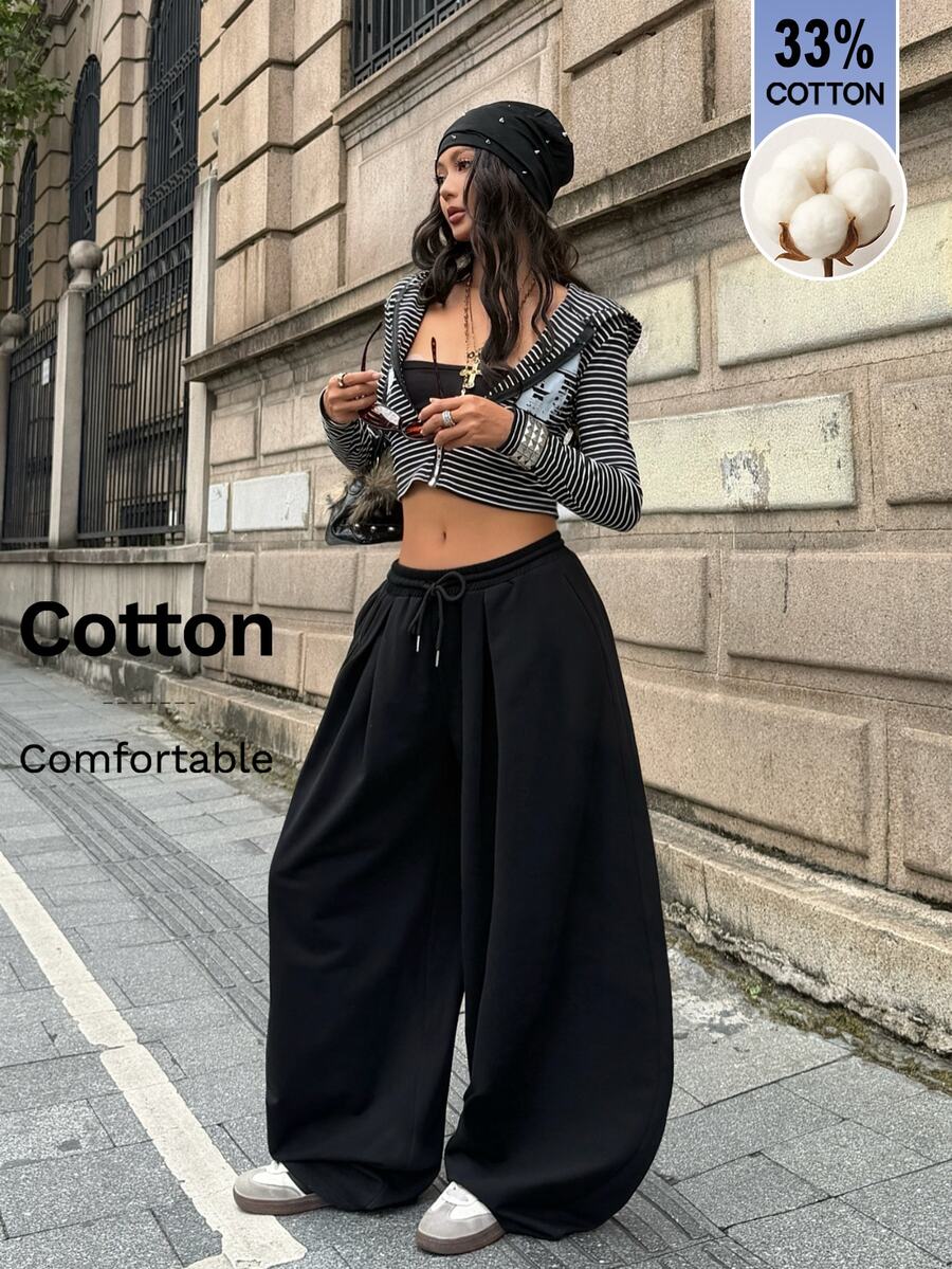 Women's casual black loose fit baggy banana pants featuring a low rise elastic drawstring waist and side pockets.