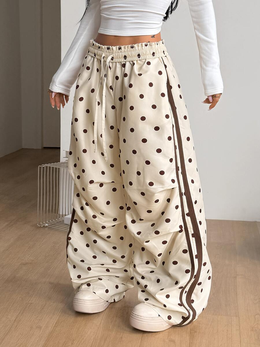 Women's black and white striped wide leg pants featuring an elastic drawstring waistband, side pockets, and a loose straight leg fit.