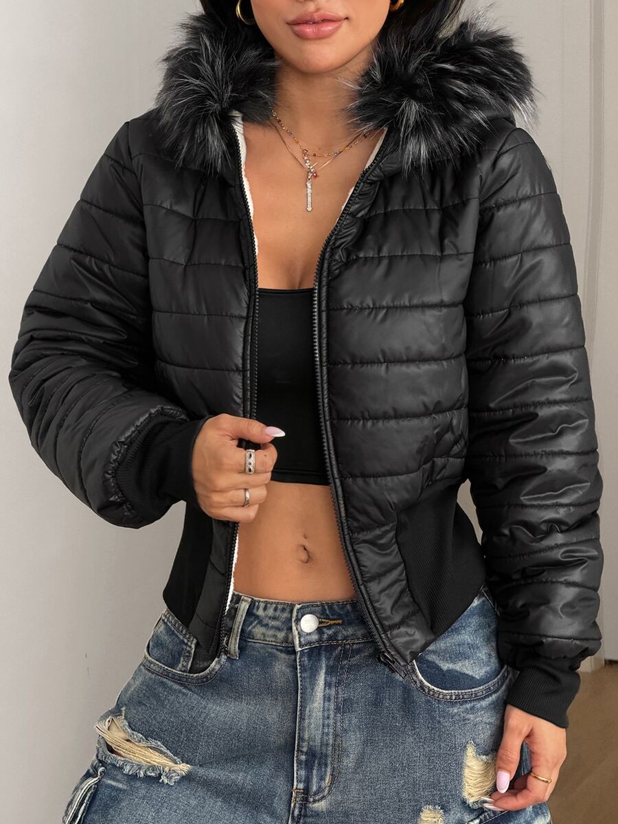 Women's brown cropped puffer jacket featuring a faux fur trimmed hood, front zipper, and ribbed hem.