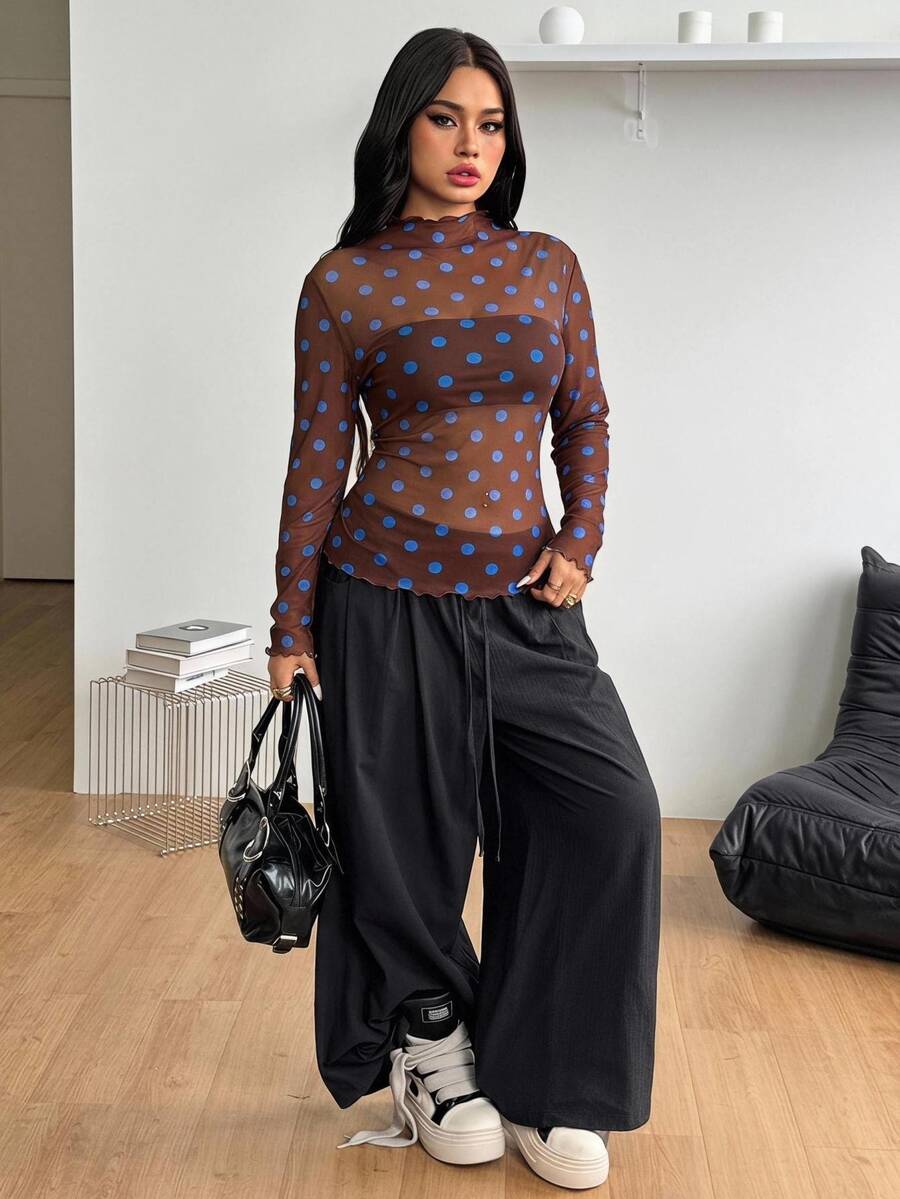 Women's brown sheer mesh long sleeve top featuring a polka dot print, stand collar, and lettuce trim details.