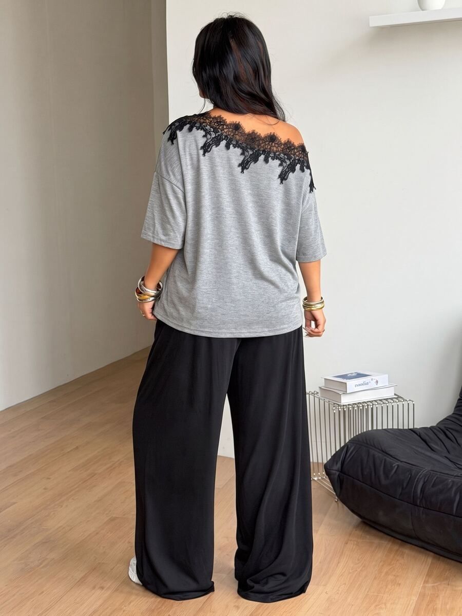 Women's casual two-piece outfit featuring a loose short-sleeve asymmetrical neck t-shirt and matching long wide leg pants with pockets.