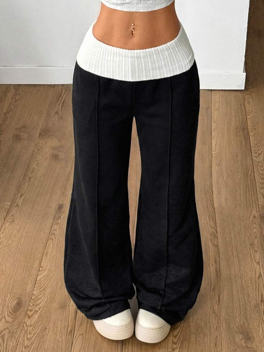 Women's wide leg flare sweatpants featuring a black and white colorblock contrast fold waistband and side stripe details.