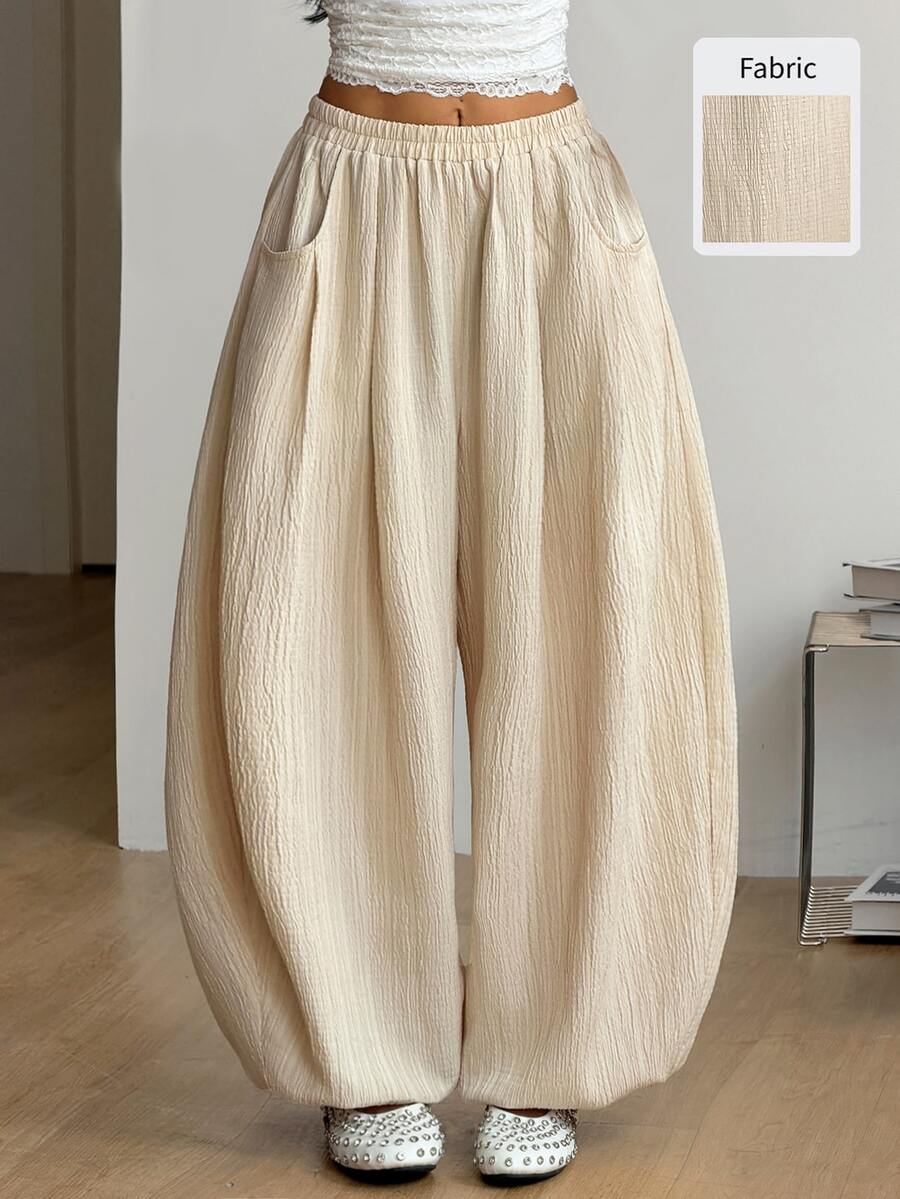 Women's loose-fit black bloomer pants made of 100% cotton featuring an elastic waistband and side pockets.