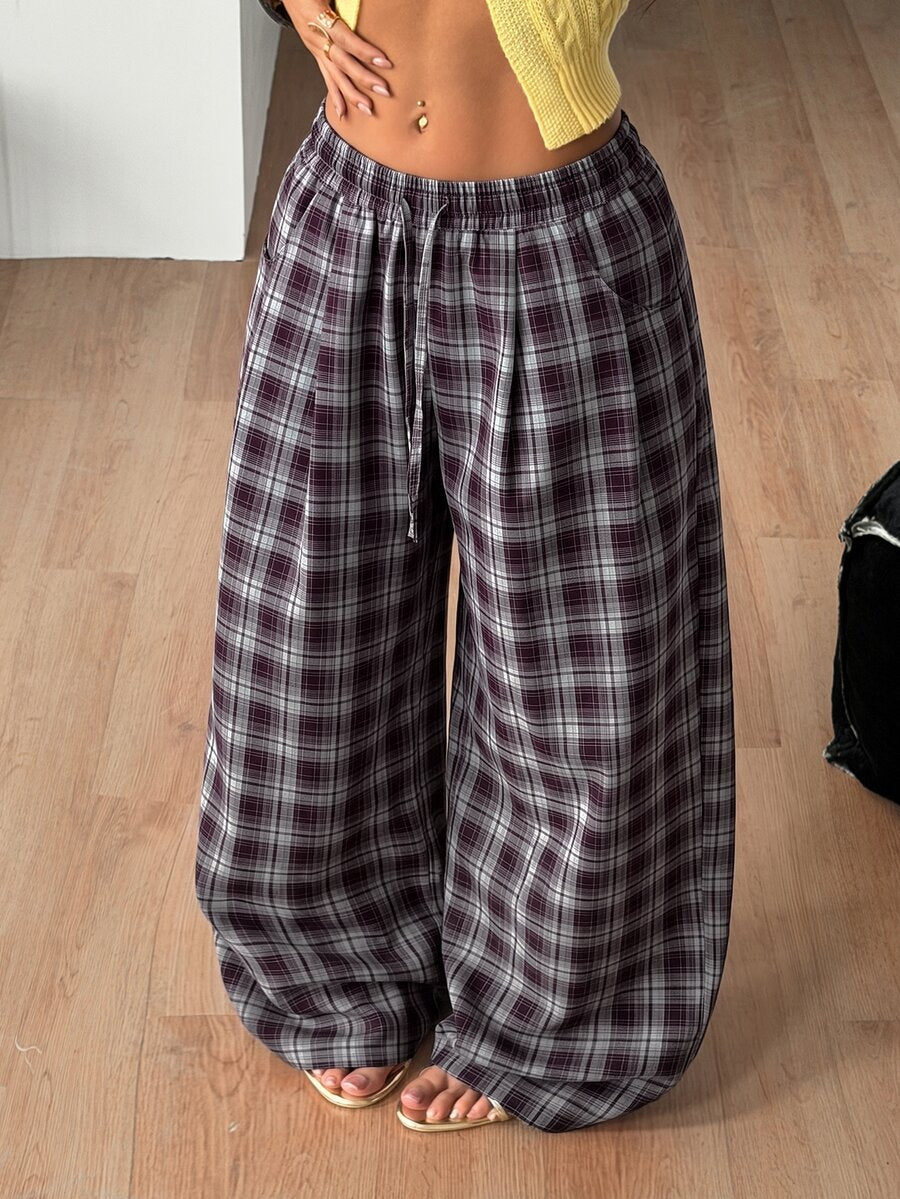 Women's loose fit brown and tan plaid wide leg pants featuring an elastic drawstring waist and side pockets.