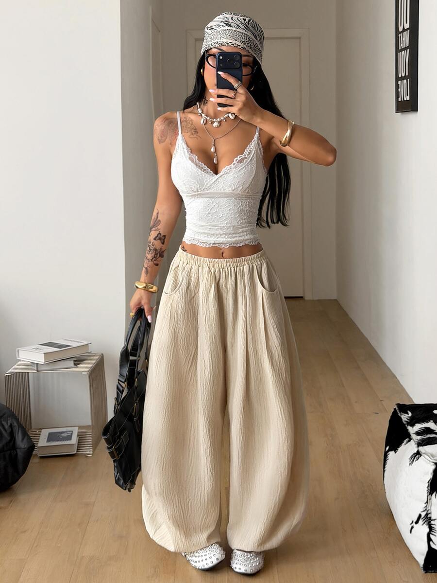 Women's loose-fit black bloomer pants made of 100% cotton featuring an elastic waistband and side pockets.