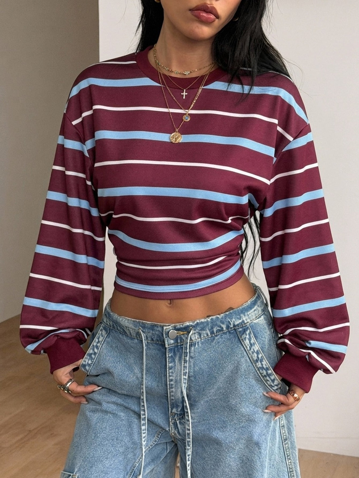 Women's striped pullover sweatshirt featuring drop shoulder long sleeves and a classic round neckline.