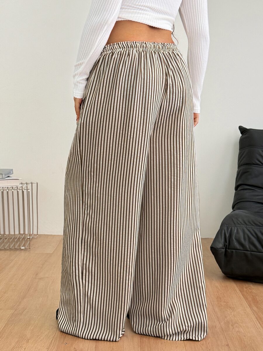 Women's loose straight leg cotton pants featuring a high waist with an adjustable drawstring knot and functional side pockets.