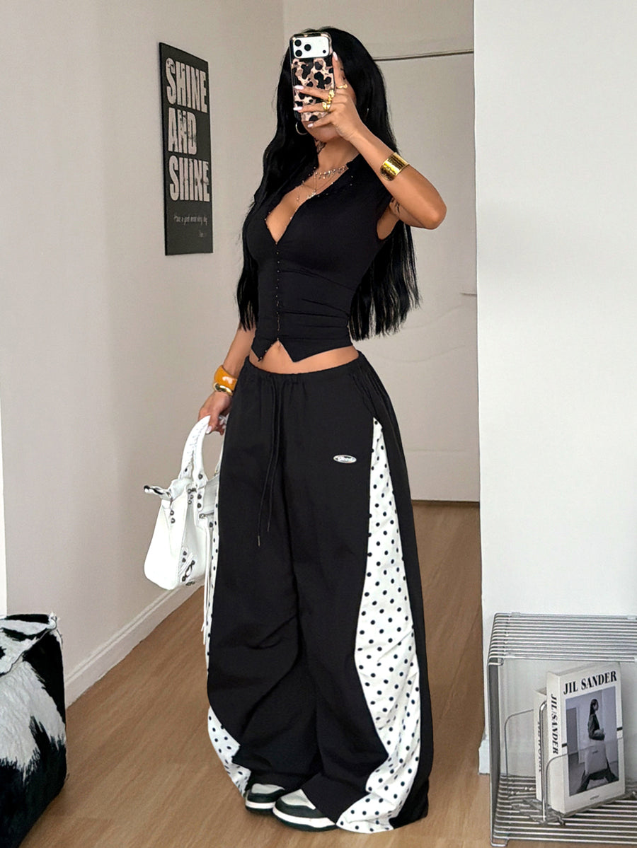 Women's black baggy jogger pants with an adjustable drawstring waist and colorblock polka dot geometric pattern.