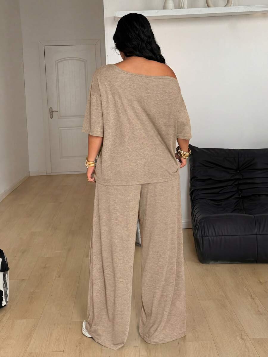 Women's casual two-piece outfit featuring a loose short-sleeve asymmetrical neck t-shirt and matching long wide leg pants with pockets.