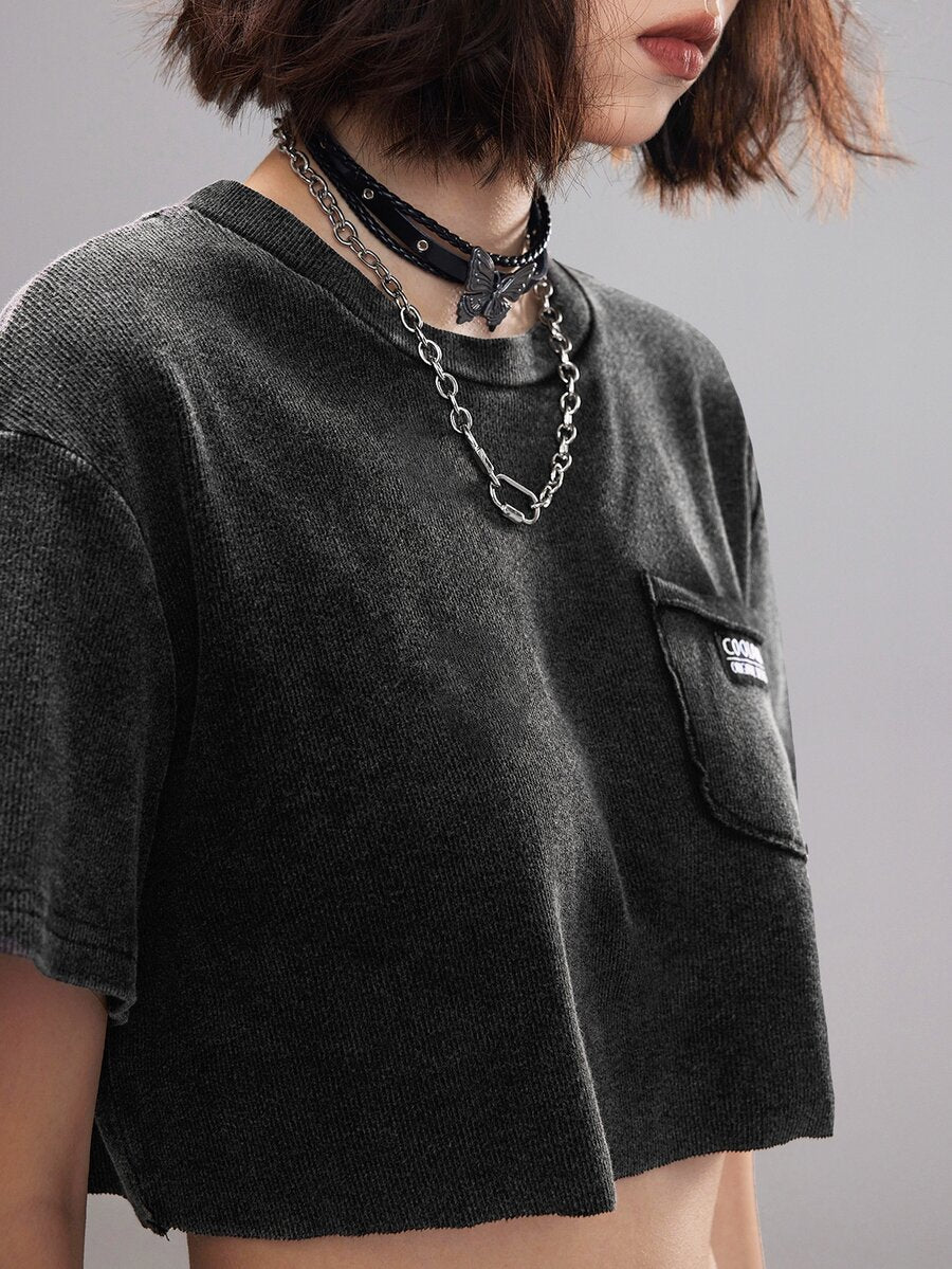 Women's short sleeve crop top with a round neckline and drop shoulder design in black knitted fabric.