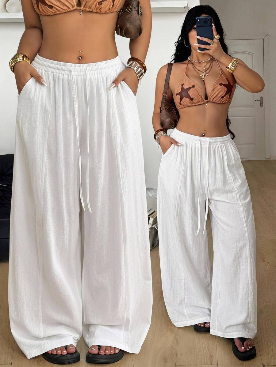 Women's loose straight leg cotton pants featuring a high waist with an adjustable drawstring knot and functional side pockets.
