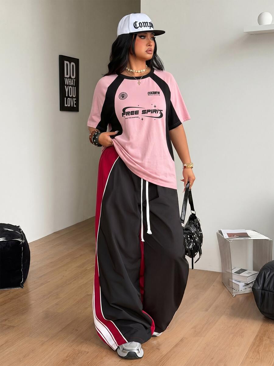 Unisex plus size oversized jersey t-shirt in brown featuring a round neck, short raglan sleeves with contrast binding, and a front letter graphic print.