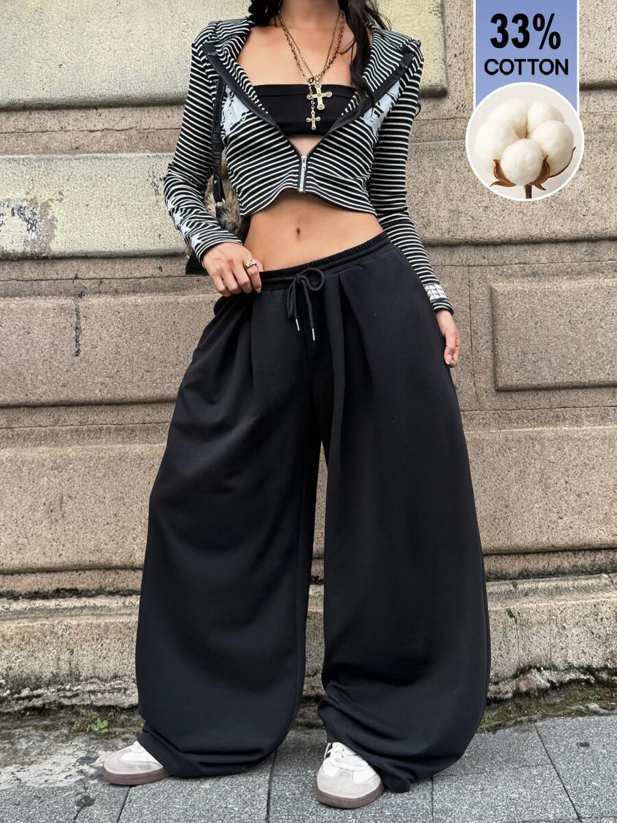 Women's casual black loose fit baggy banana pants featuring a low rise elastic drawstring waist and side pockets.