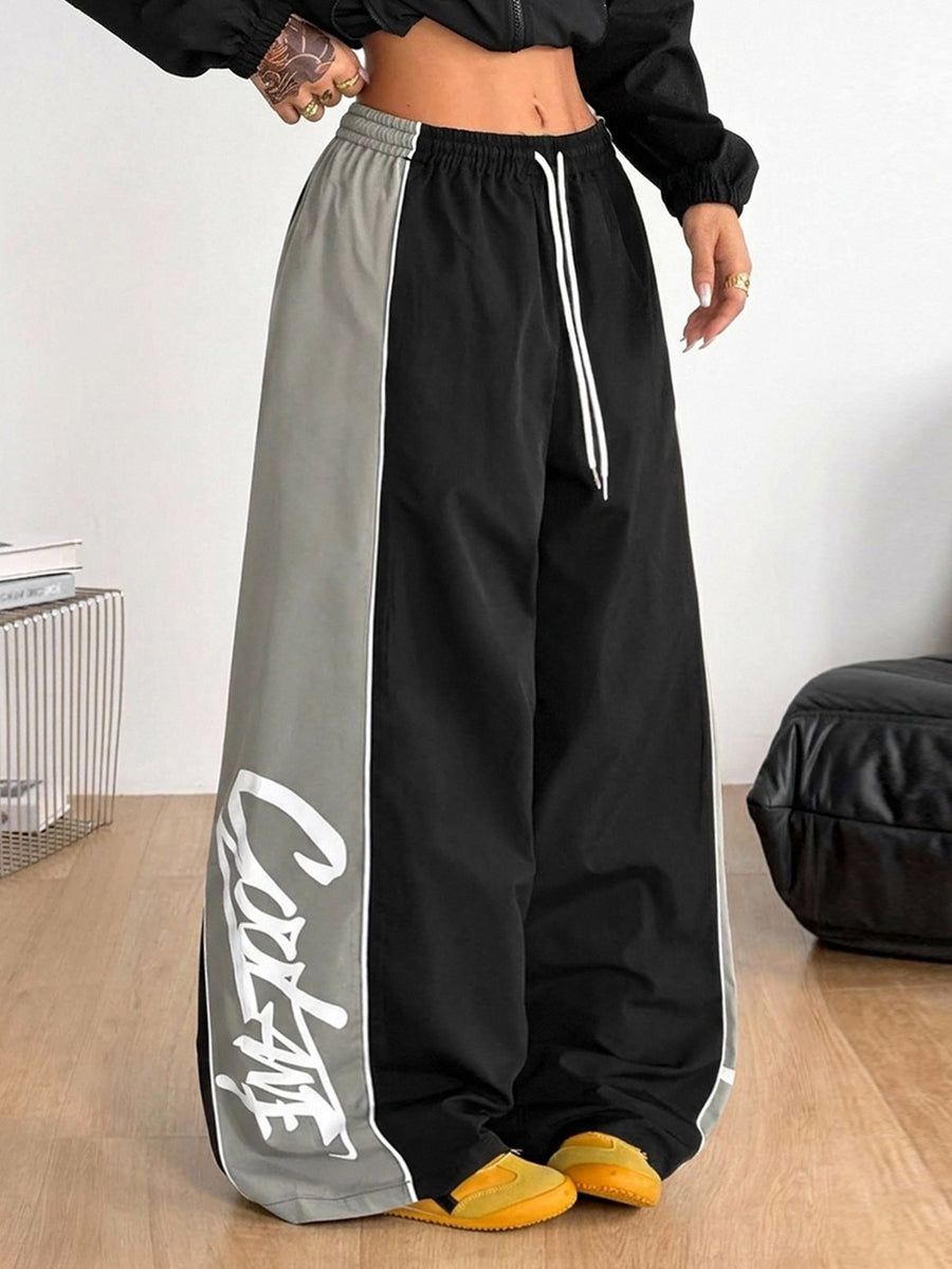 Women's black loose fit wide leg pants featuring an elastic waistband and side pockets with contrast binding.