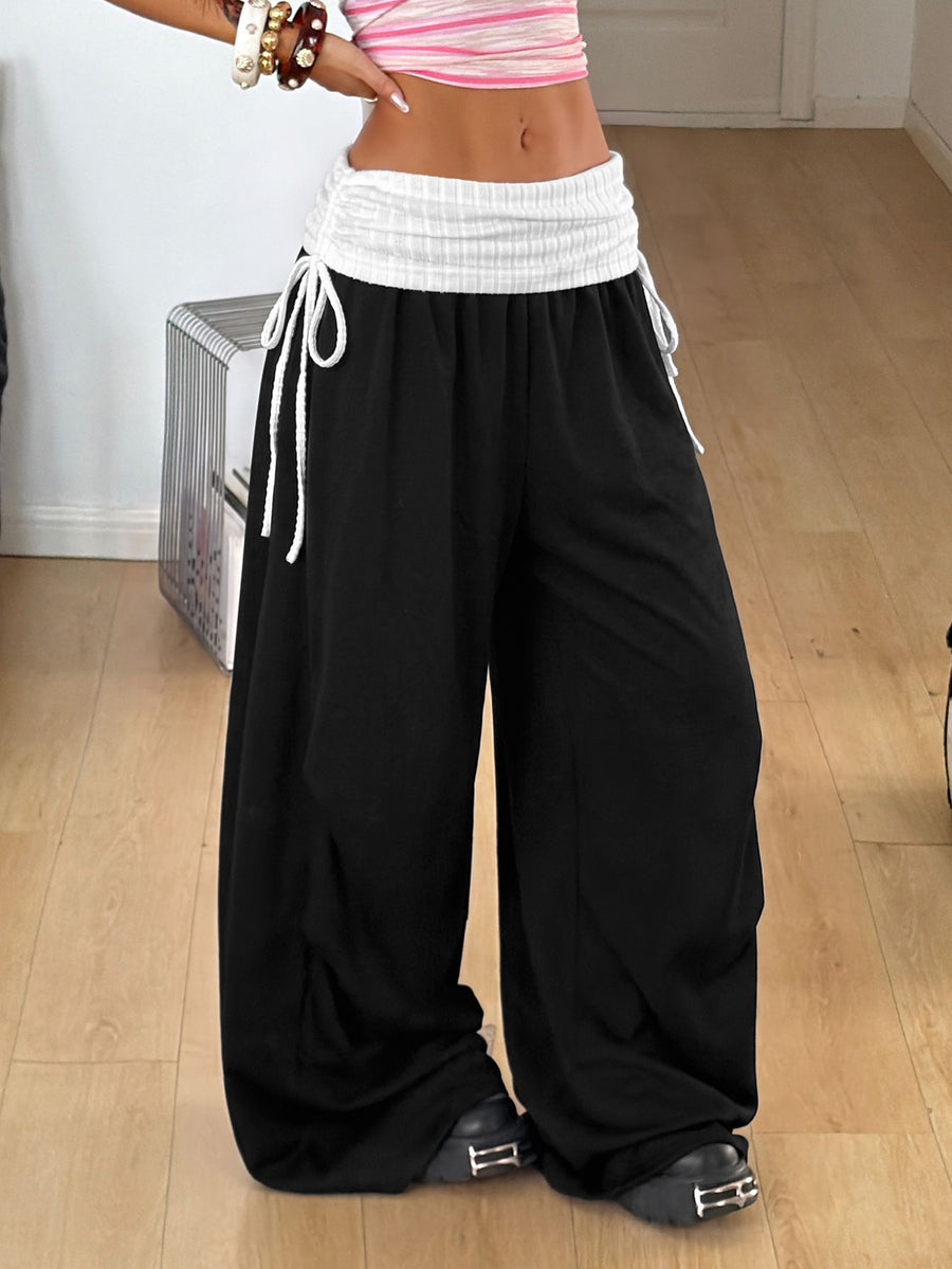 Women's loose fit wide leg jogger pants in black with white drawstring tie detail and elastic waistband.