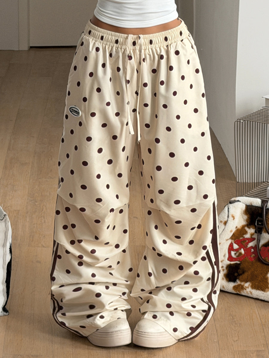 Women's black and white striped wide leg pants featuring an elastic drawstring waistband, side pockets, and a loose straight leg fit.