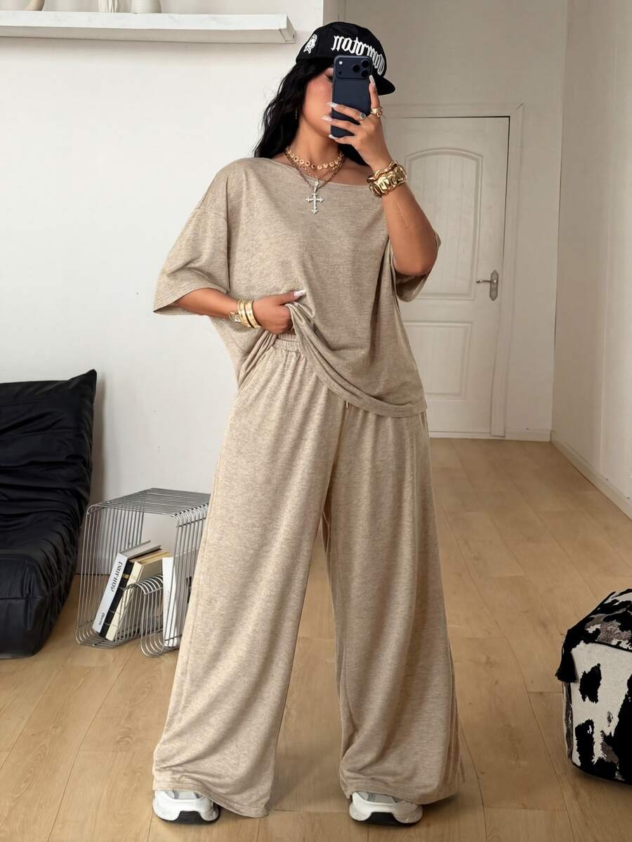 Women's casual two-piece outfit featuring a loose short-sleeve asymmetrical neck t-shirt and matching long wide leg pants with pockets.