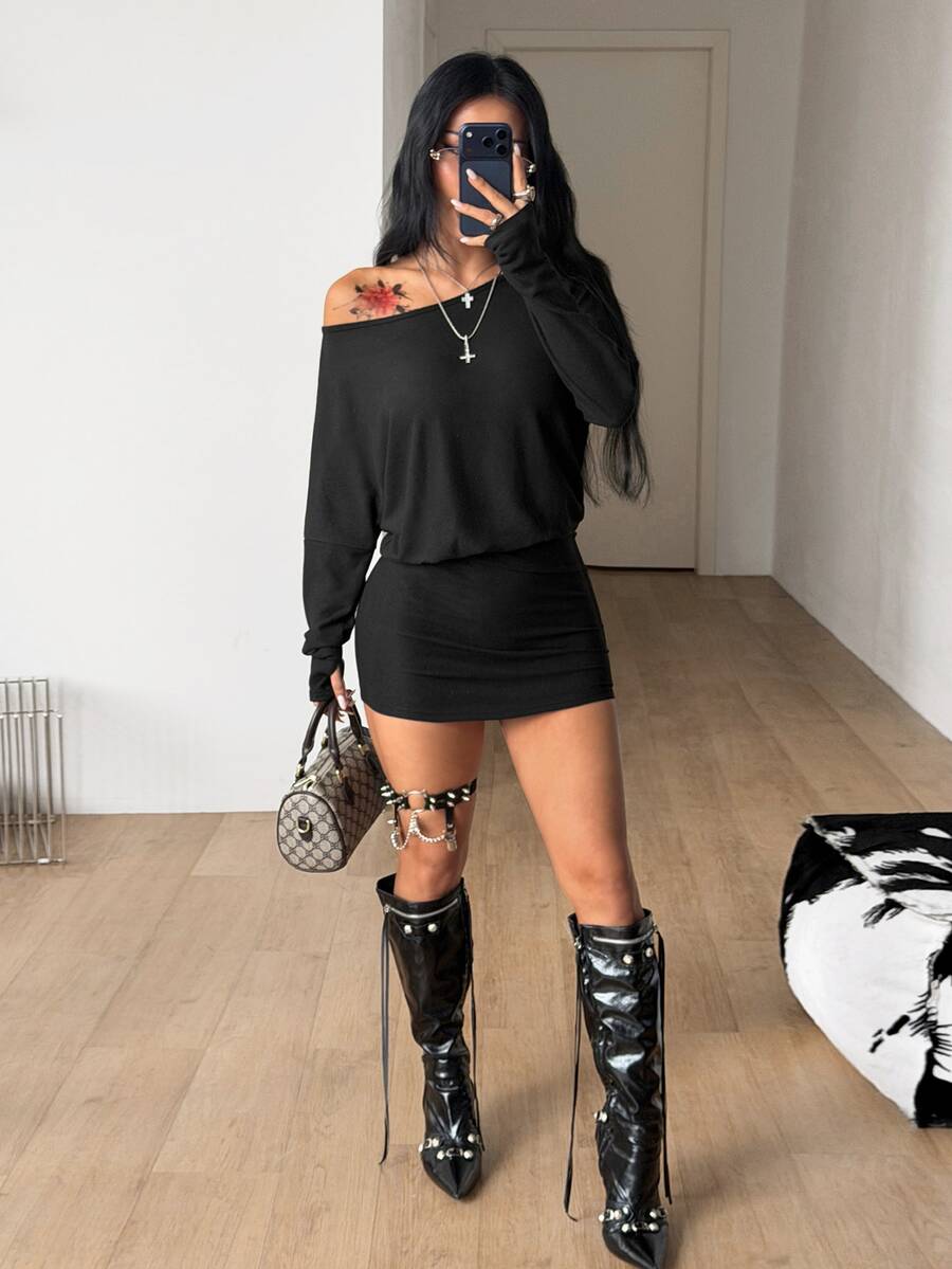 Women's long sleeve bodycon mini dress in black knitted fabric with an asymmetrical neckline and ruched accents.