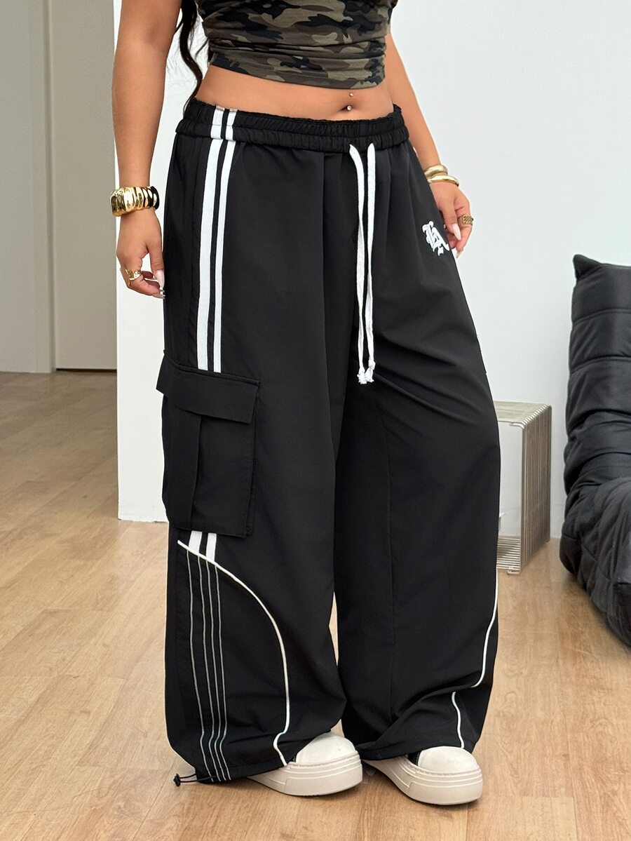 Women's plus size loose straight leg pants featuring a black and white color block design with side stripes and an elastic drawstring waist.