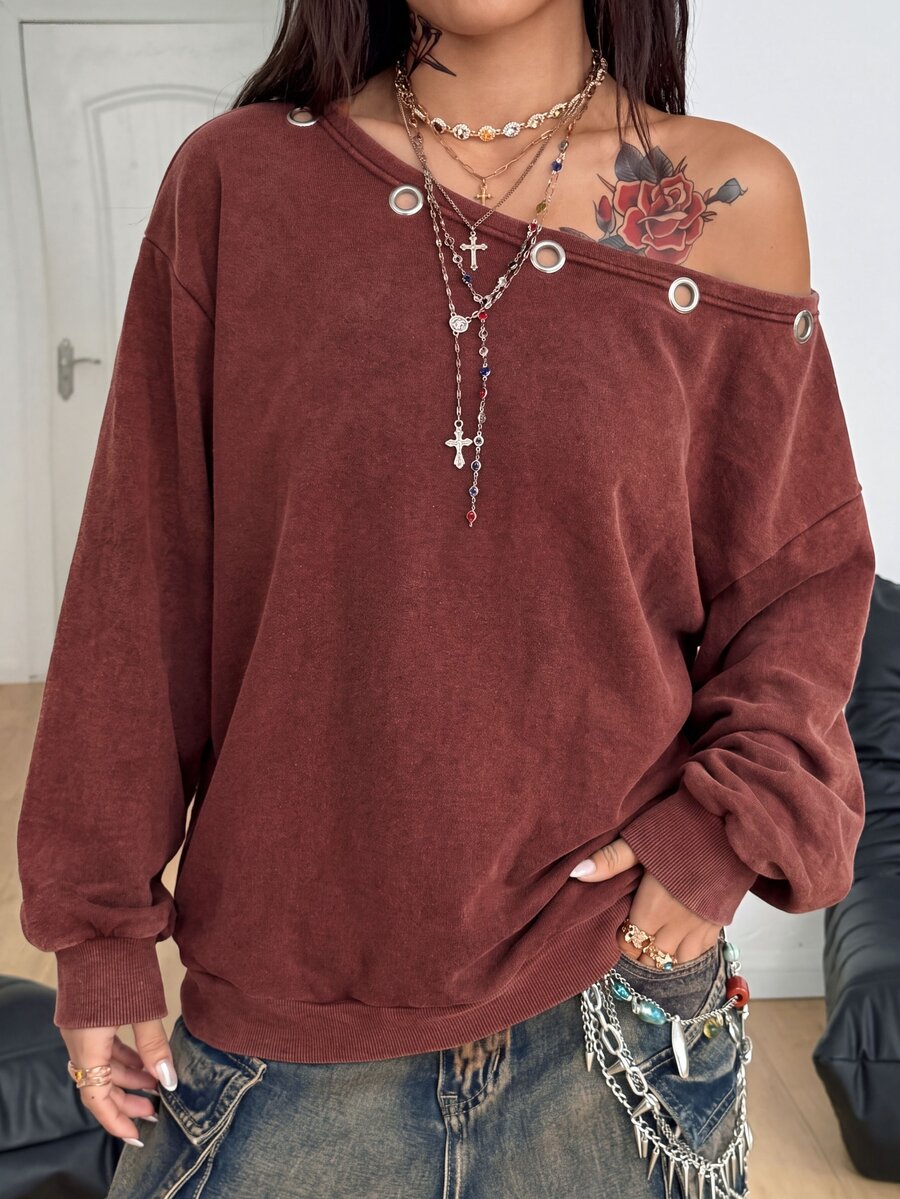 Women's oversized dark grey long sleeve sweatshirt featuring an asymmetrical boat neckline with grommet eyelet details and drop shoulders.