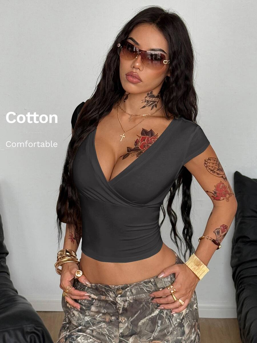 Women's slim fit V-neck short sleeve crop t-shirt featuring ruched wrap detailing in stretch knit fabric.