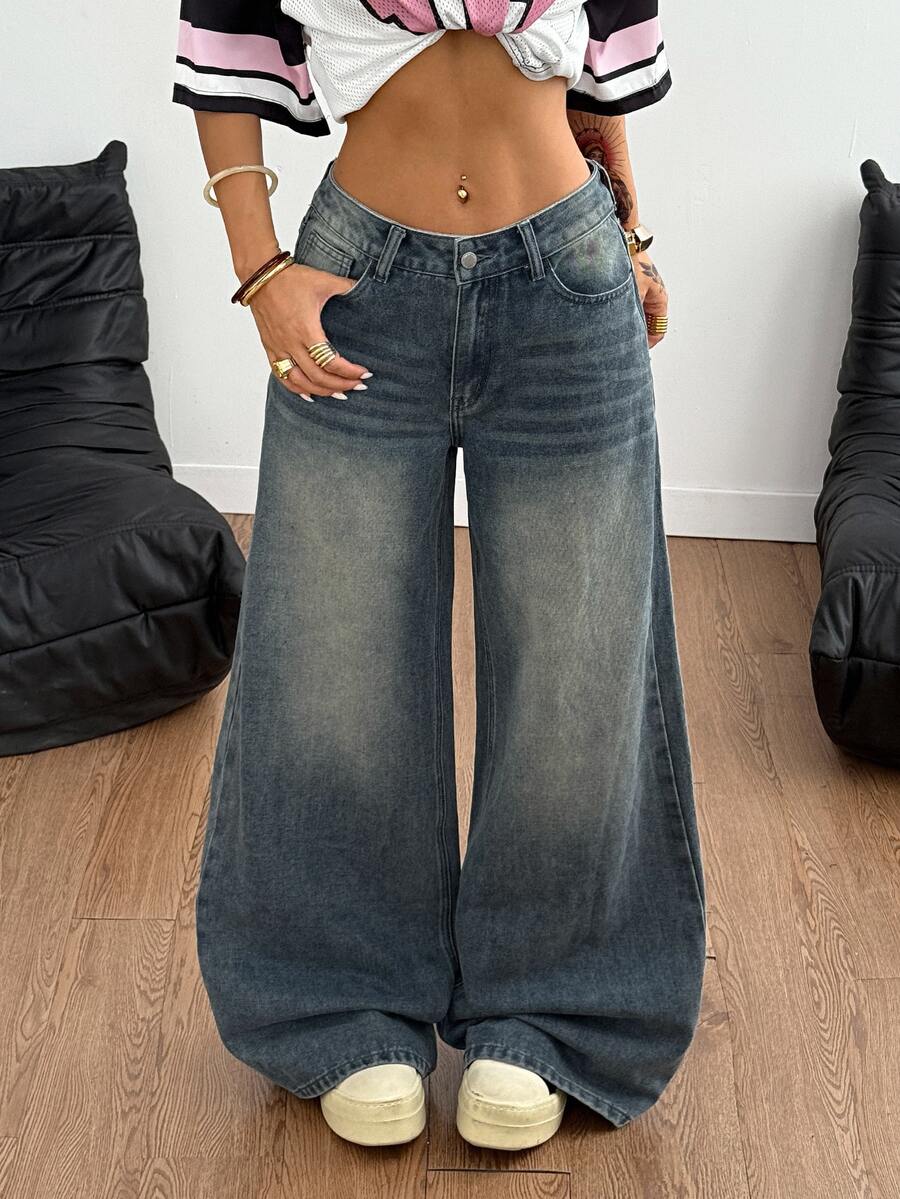 Loose wide leg denim jeans for women featuring a low waist, functional pockets, zipper fly closure, and extra long relaxed fit.