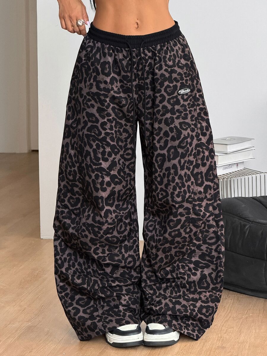 Women's black baggy jogger pants with an adjustable drawstring waist and colorblock polka dot geometric pattern.