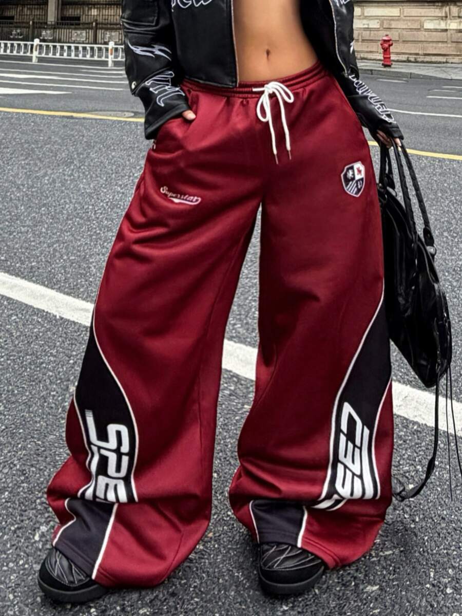 Women's loose fit wide leg graphic sweatpants in light grey with an elastic drawstring waistband
